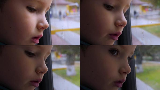 孩子在窗户里倒影，玻璃。一个孩子在火车上向窗外看的特写镜头。坐火车旅行。这个男孩看着跑步的风景。春天
