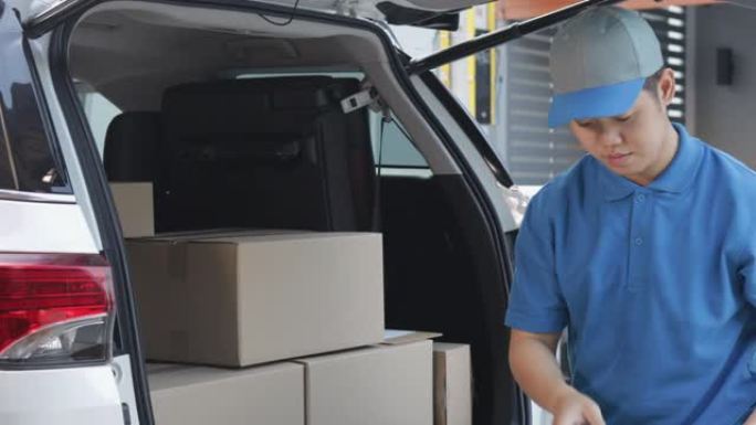 送货员将包裹邮筒装在纸箱中，并在交付给客户之前检查包裹邮筒的库存。送货上门的概念。