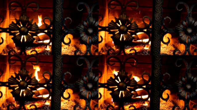 木质原木燃烧着橙色火焰，在铁门的砖壁炉中发光。