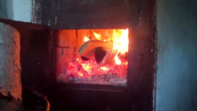 在炉膛里扔木头壁炉取暖打开炉门添加干柴