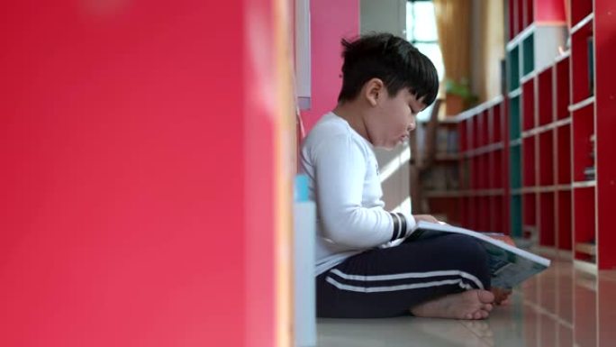 亚洲男孩在学校图书馆读书，教育理念。4k多莉射门。
