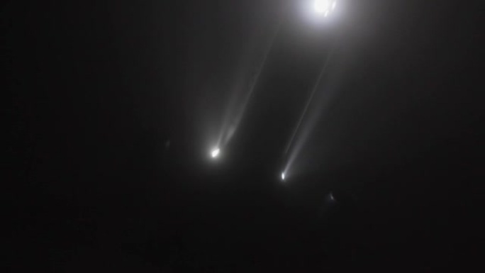 飞机降落在雾中，大灯穿过