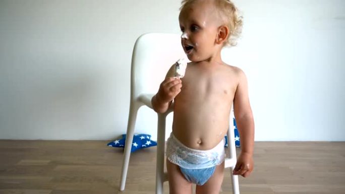 肮脏的金发男孩在棍子上吃巧克力冰淇淋。万向节运动