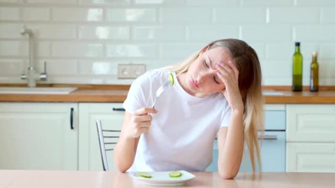 沮丧的饮食女人在盘子里吃黄瓜