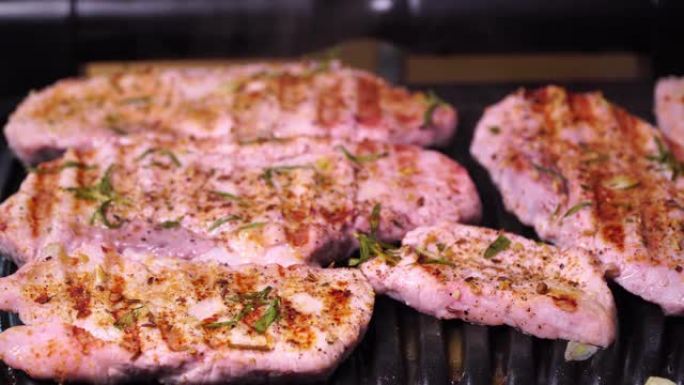 猪肉生产特写。在烤架上油炸的猪肉牛排