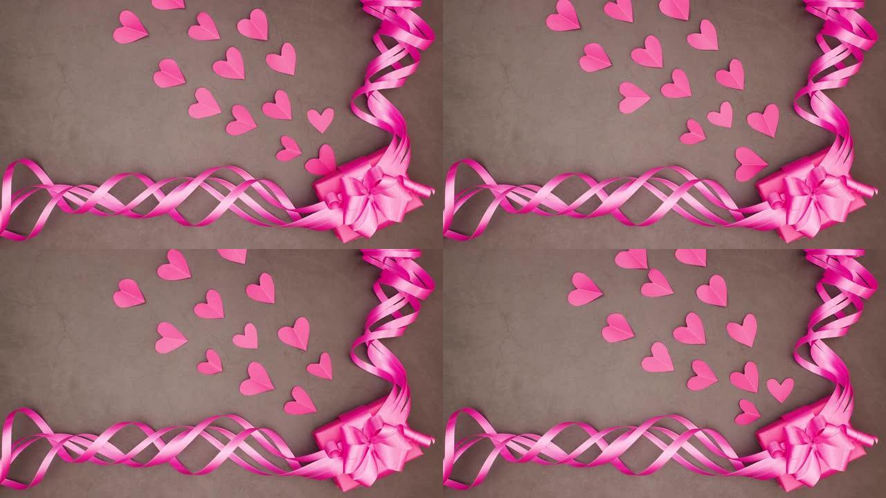 粉红色的心从粉红色的女孩礼品盒中出来，带有大的粉红色丝带-停止运动