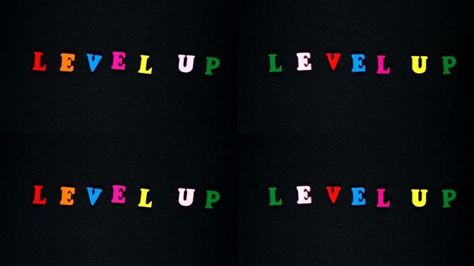 由木制五彩字母组成的单词 “level up”。五颜六色的单词循环。