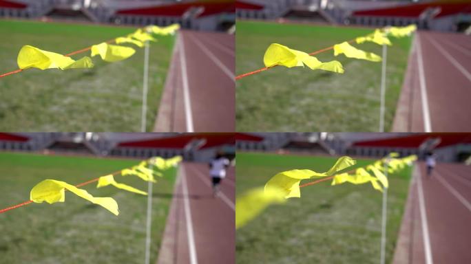 体育场的跑道。焦点在飘扬的黄旗上。主题在左边。