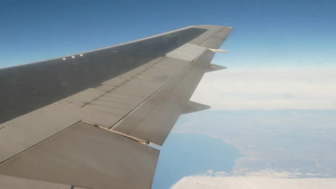 白云下的飞机机翼坐飞机拍摄飞机飞行