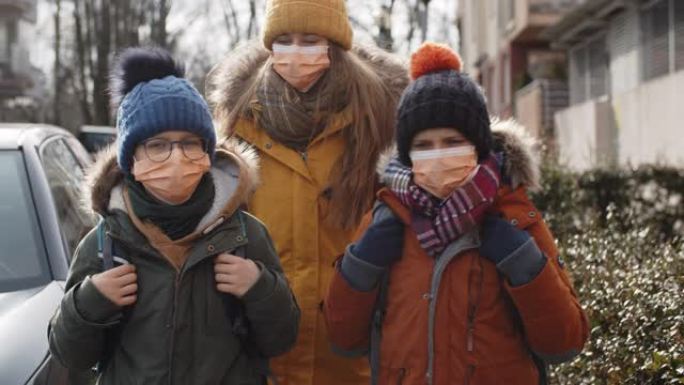 三个孩子戴着防病毒面具上学