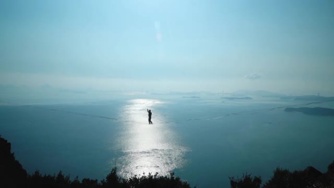 男人在山上放松，背后是天空和大海