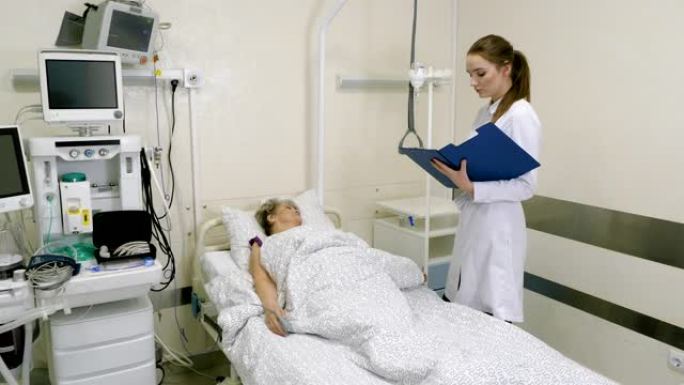 女医生在医院病床上检查老年妇女。4K