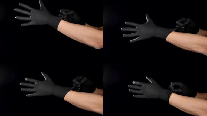 男性医生在手术前戴上黑色防护手套，拍摄于黑色背景。慢动作视频。移动男性的手戴上检查或医用手套。全高清