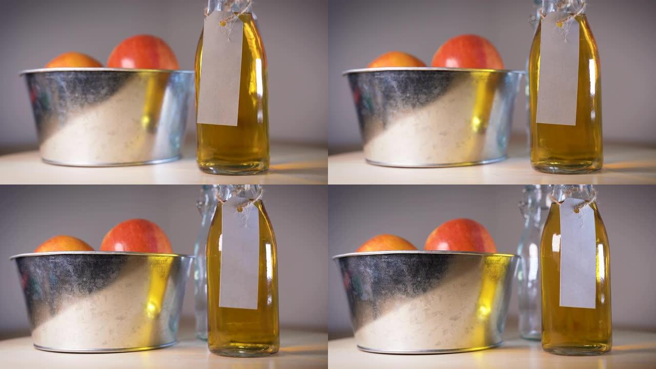 木桌上篮子里的玻璃瓶苹果汁和苹果的特写视图