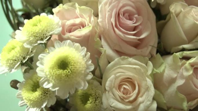 在木棍框架上构图一束白玫瑰和菊花