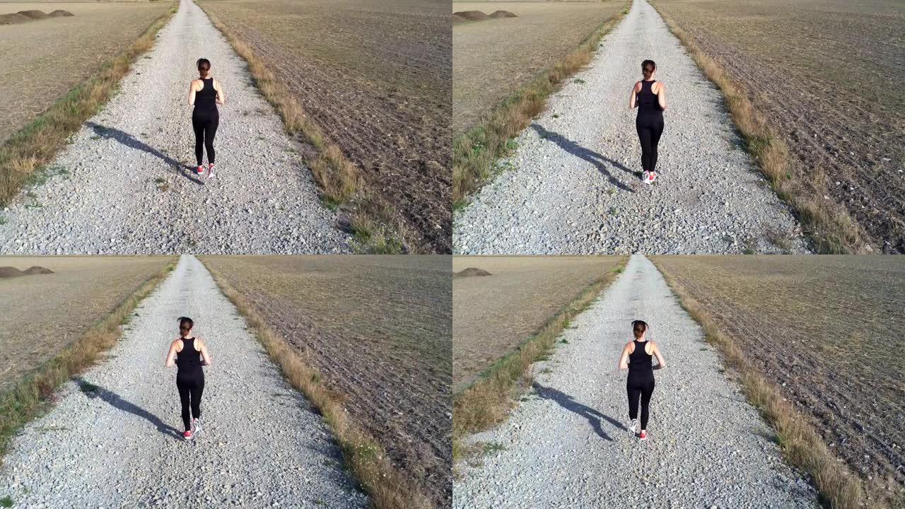 女人在一条长长的土路上慢跑