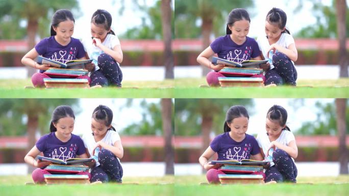 两个亚洲女孩在花园里读书