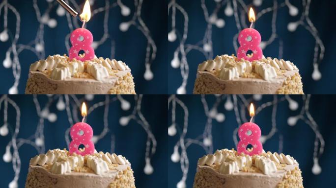 蓝色背景上有8号粉色蜡烛的生日蛋糕。蜡烛着火了。慢动作和特写视图