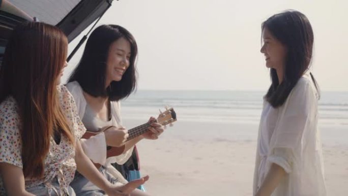 微笑快乐的朋友年轻的亚洲妇女团体自由在海滩上玩尤克里里歌曲暑假在后备箱掀背车公路旅行和旅行周末旅行，