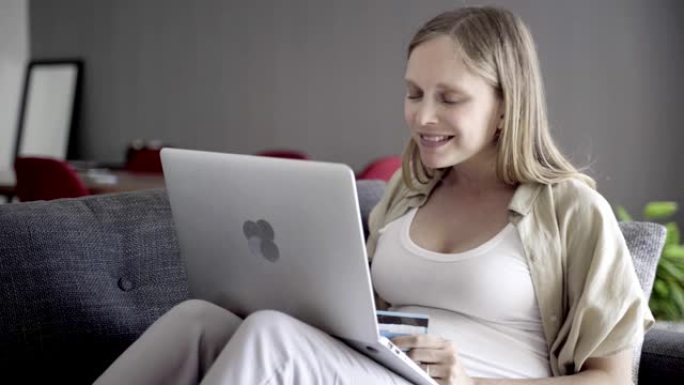 开朗的孕妇用笔记本电脑在线购物