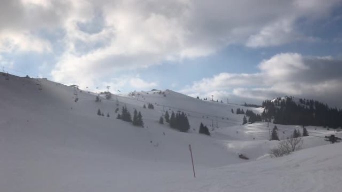 田园诗般的滑雪胜地的冬季风景，可以看到纽扣滑雪缆车和4k远处的滑雪者