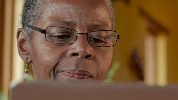 老年高级黑人妇女在看电脑显示器时思考
