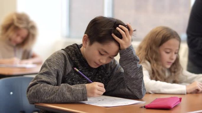 一个年轻的亚洲男孩在课堂上集中注意力的慢动作镜头