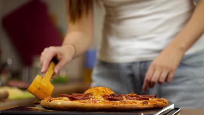 女厨师用木铲将新鲜准备的意大利辣香肠比萨饼和奶酪放在烤盘上。顶视图延时全高清视频。