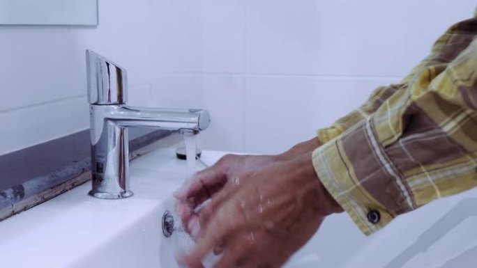 男人打开/关闭水龙头，在马桶里洗手，用手关闭。