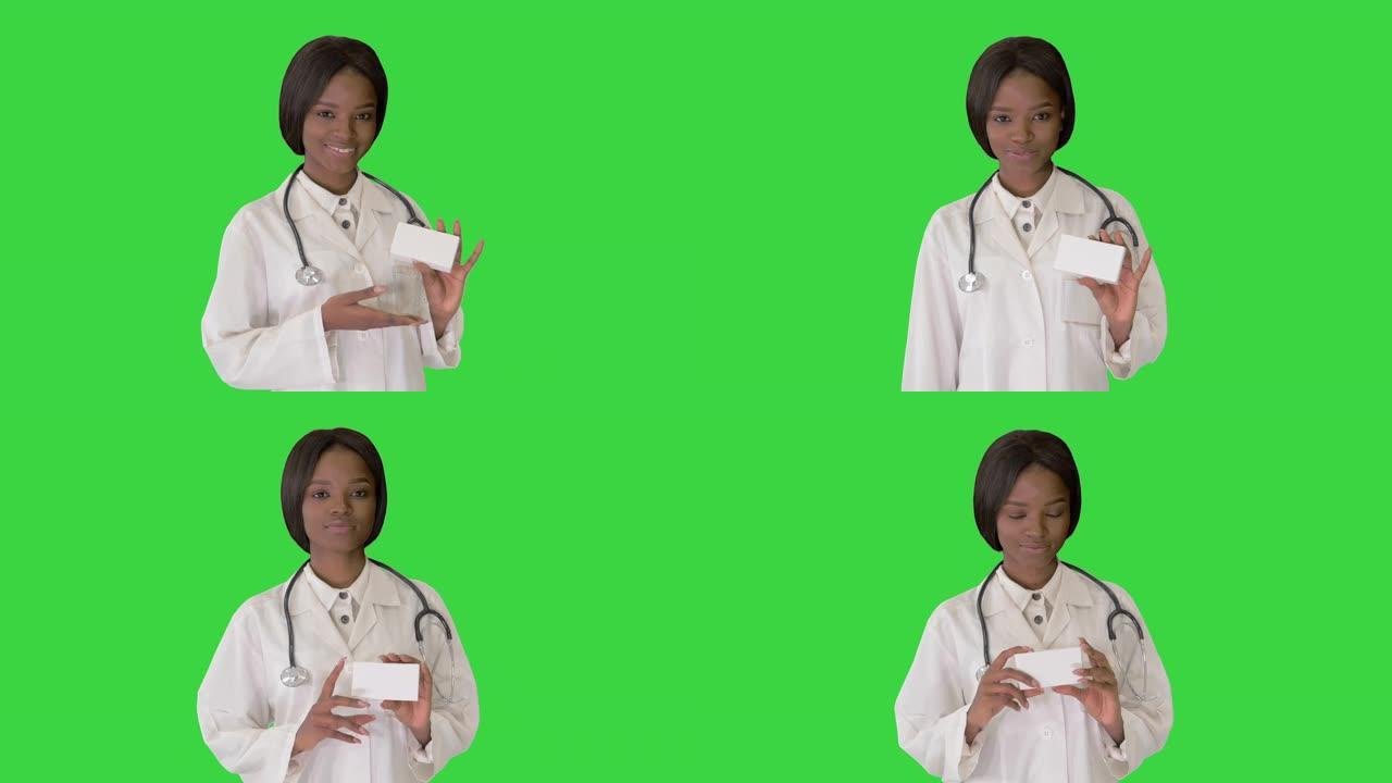 女医生微笑着在绿色屏幕上拿着一盒药物，色度键
