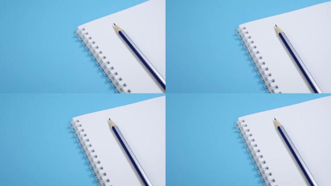 蓝色背景上有铅笔的纸质记事本