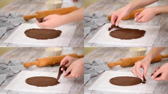 糕点师傅在厨房做巧克力层蛋糕。妇女的手与生巧克力面团一起工作。