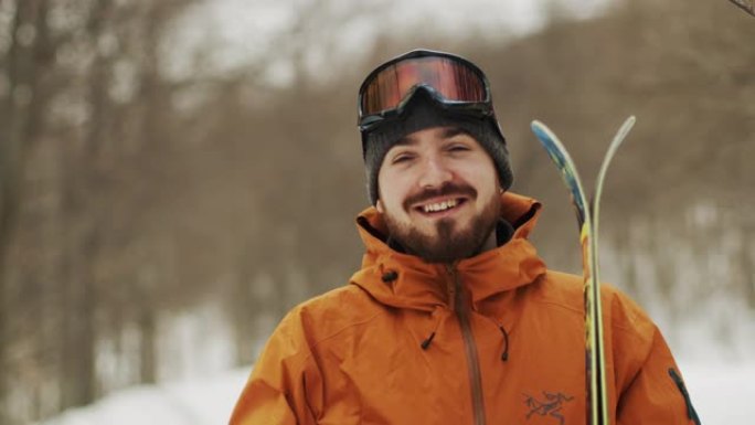 在山区度假胜地，一个戴着头盔和滑雪板的年轻人的特写镜头。他穿上雪地谷歌。寒假概念。慢镜头股票视频