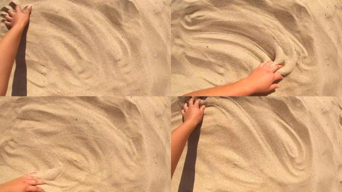 手在沙子表面移动，俯视图。