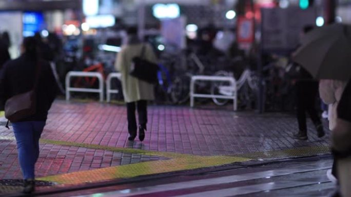 晚上在新宿东京下雨天在十字路口散步的人