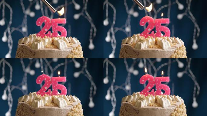 蓝色背景上有25号粉色蜡烛的生日蛋糕。蜡烛着火了。慢动作和特写视图