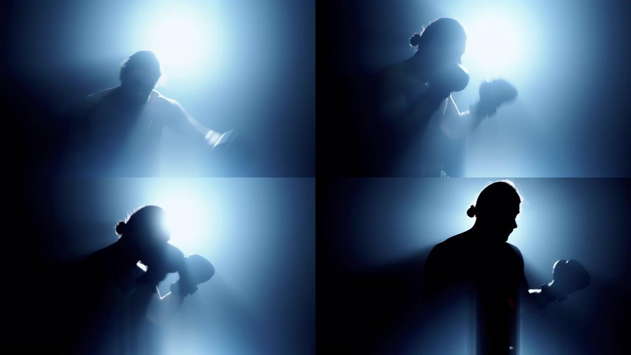 男子戴着拳击手套做太极拳动作的剪影身后有光，侧射有雾和漏光效果。高加索男性。中枪。