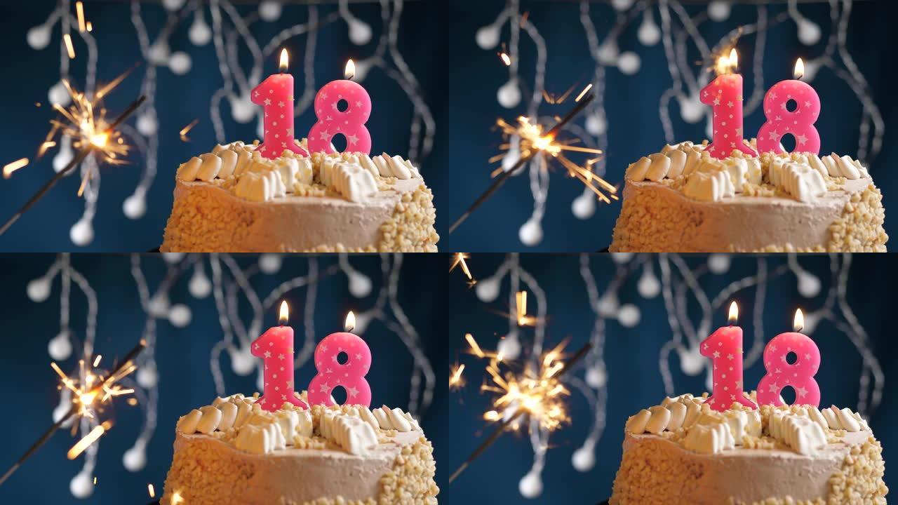 生日蛋糕，配有18号粉色蜡烛和蓝色背景上的烟火。慢动作和特写视图