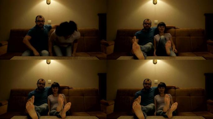 夫妻在电视上看电影。放松的夫妇在舒适的客厅的沙发上看电视。一对恋人在客厅的沙发上看电视。