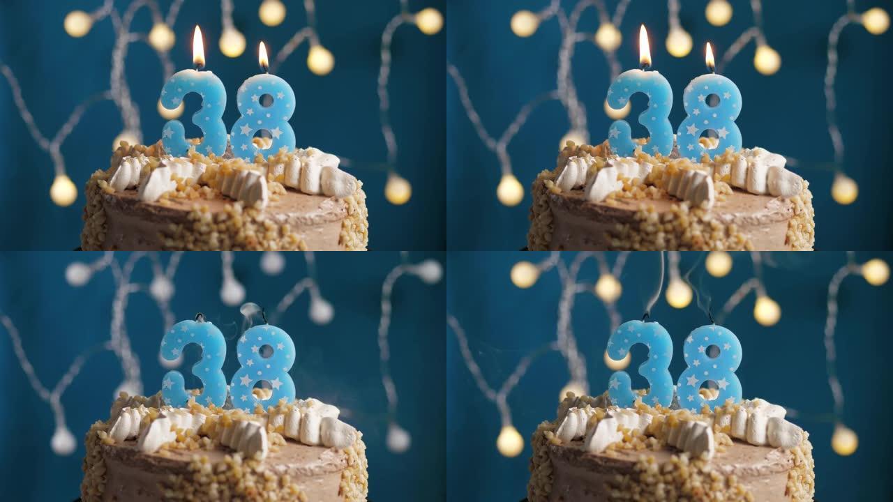 蓝色背景上有38号蜡烛的生日蛋糕。蜡烛吹灭了。慢动作和特写视图