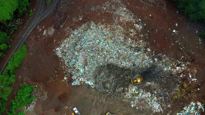 一个巨大的露天垃圾填埋场的鸟瞰图。推土机将垃圾填埋场中的垃圾和塑料废料压实。生态问题，环境污染4K