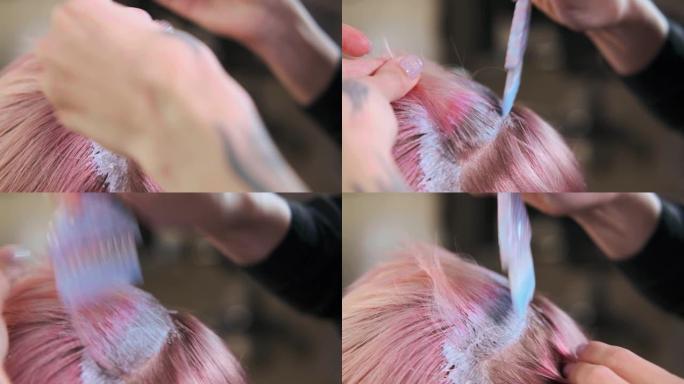 美发师调色师在女客户的头发上涂上油漆。