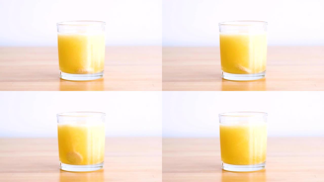 橙色维生素片剂泡腾片在杯中与水