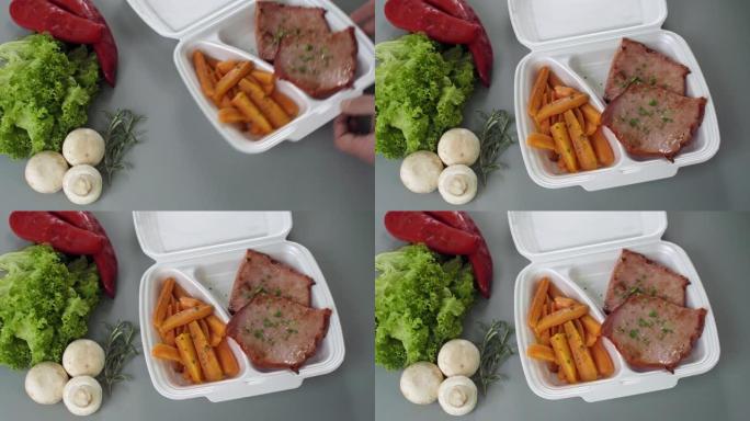 将外卖食品包装在聚苯乙烯泡沫塑料盒中。新鲜送餐套餐配烟熏牛里脊肉和胡萝卜