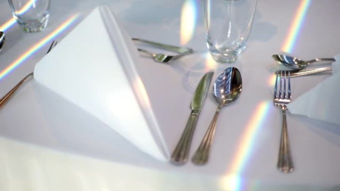 桌子上摆着餐具、餐巾和玻璃。