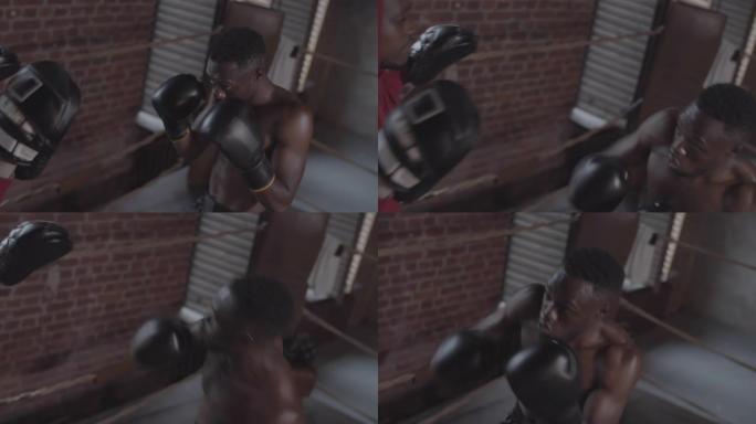 美国黑人拳击手在拳击场中拳打焦点手套