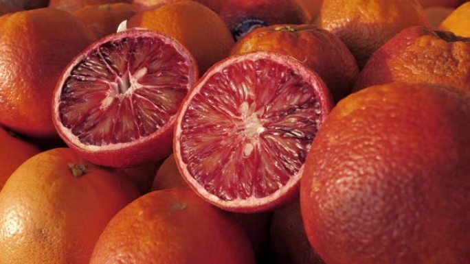 水果市场上新鲜血液橙子的特写镜头。农贸市场上装满成熟橙子的盒子。商店里的有机水果展示。蔬菜水果店摊位