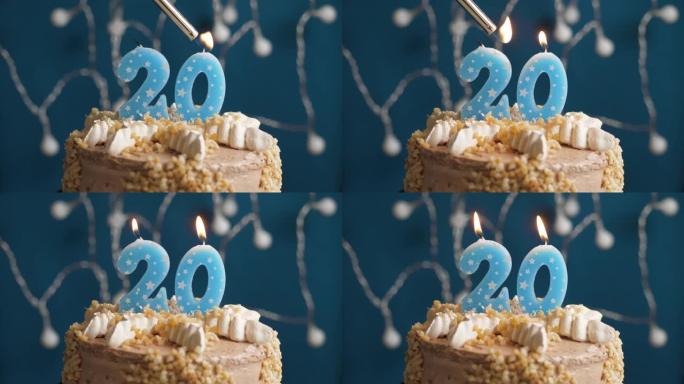 蓝色背景上有20号蜡烛的生日蛋糕。蜡烛着火了。慢动作和特写视图