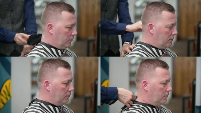 理发店的男士理发。主人的特写镜头使用吹风机和刷子完成头发造型