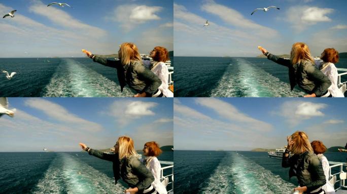 两名妇女在游轮甲板上用面包手工喂养海鸥。希腊。4K
